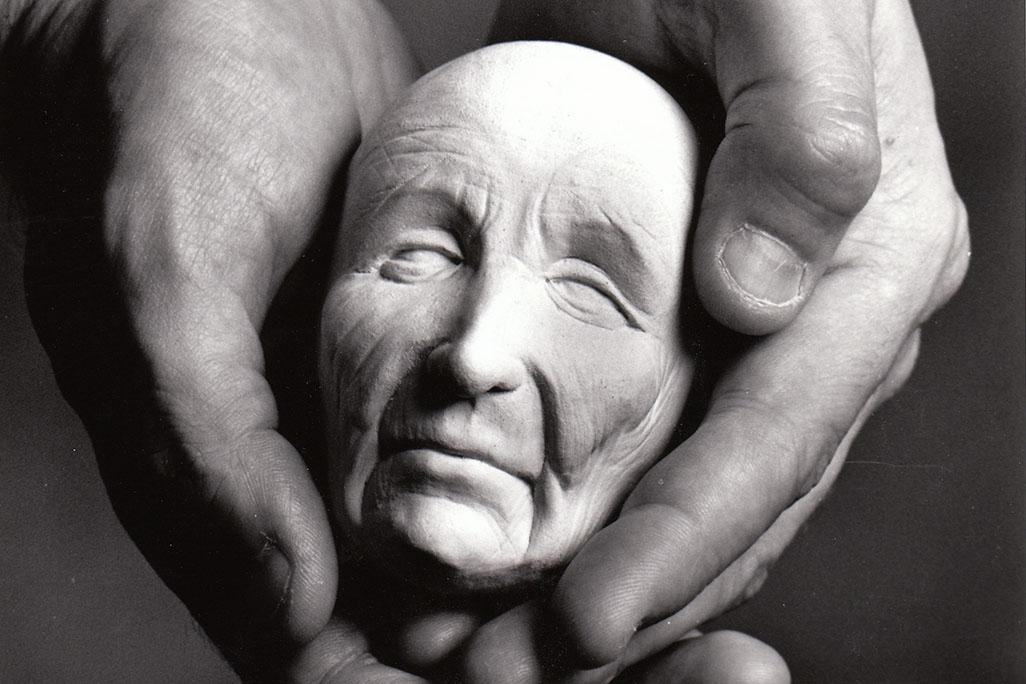 Black and white image of a marionette puppet's head being held